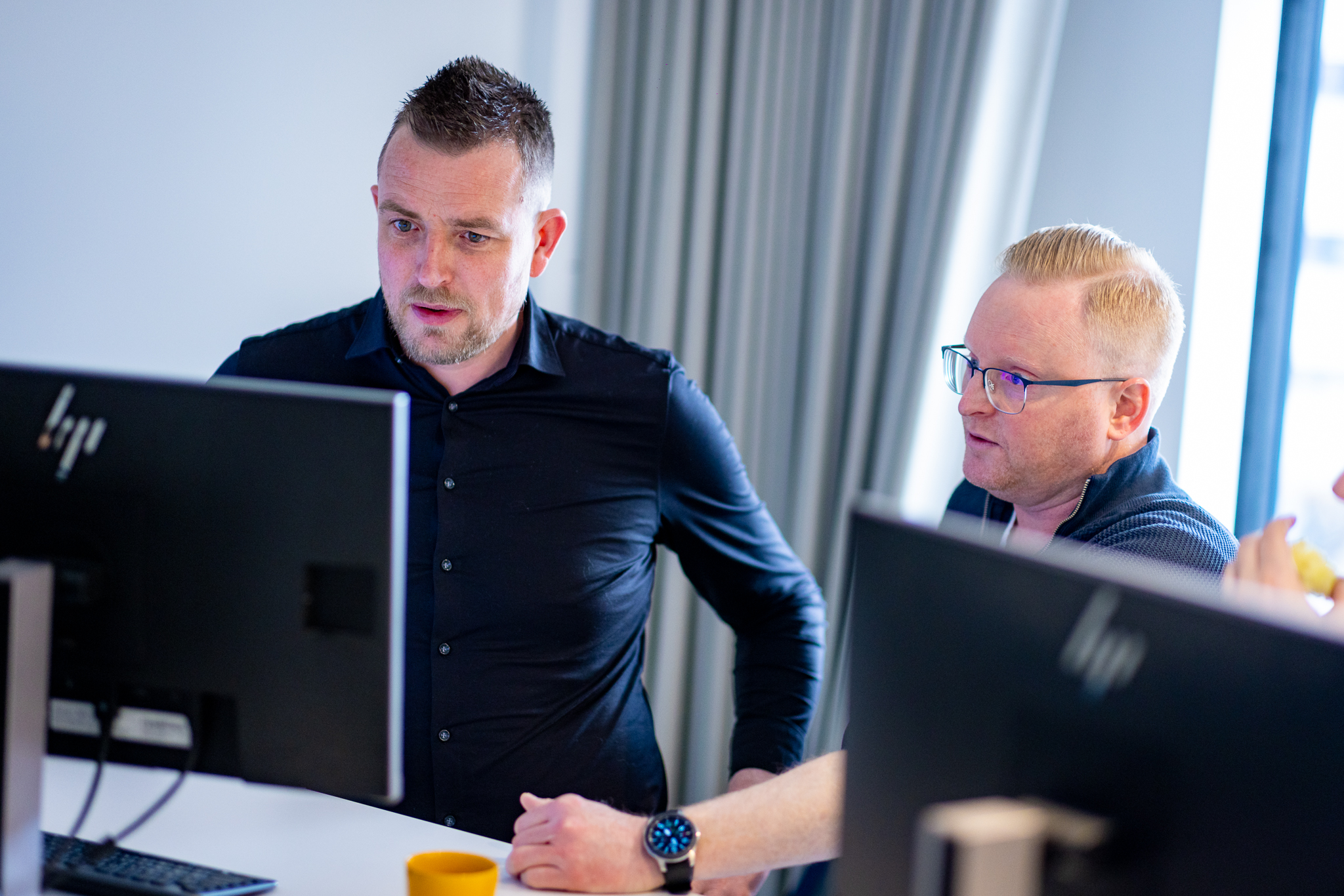 Twee mannen kijkend naar computerscherm