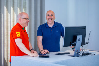Twee mannen achter bureau met computer